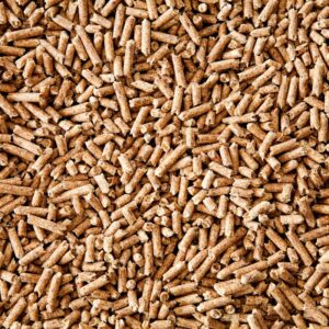 Close-up of a dense layer of wood pellets, showcasing their organic texture and uniform size, commonly used for heating and animal bedding.