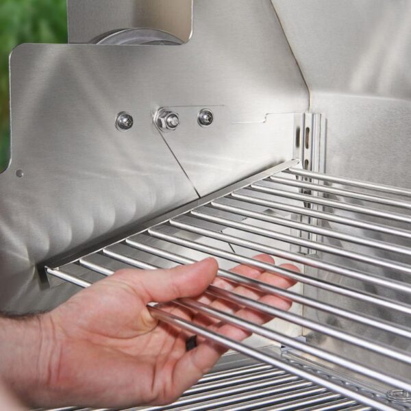 Close-up of a hand adjusting stainless steel grill grates inside a barbecue, highlighting the grill's metallic finish and precise construction.