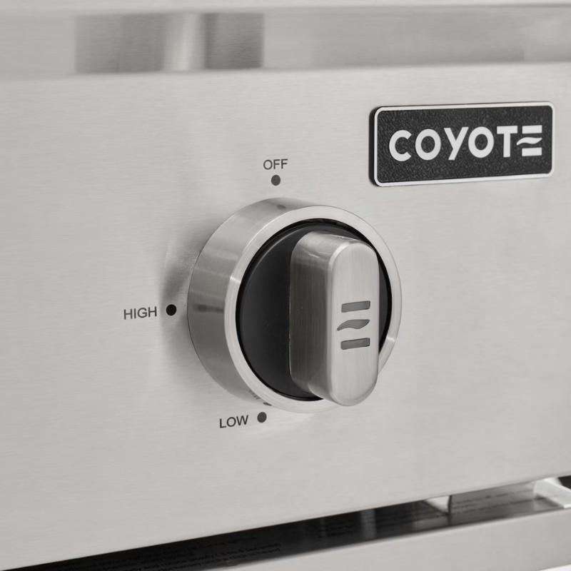 Close-up of a stainless steel control knob on a Coyote grill, featuring settings for high, low, and off positions.