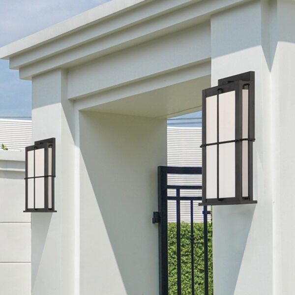 Modern outdoor lighting fixtures flanking a white wall entrance, featuring a sleek black frame and illuminated panels, enhancing the entryway aesthetics.