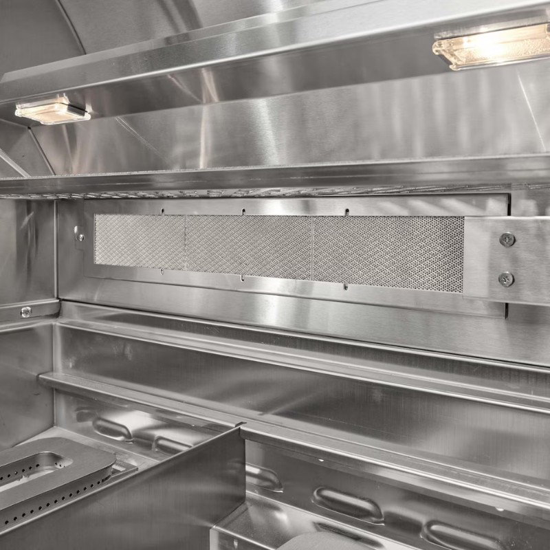 Interior view of a stainless steel kitchen hood featuring a mesh filter and built-in lighting, designed for efficient ventilation and smoke removal in cooking environments.