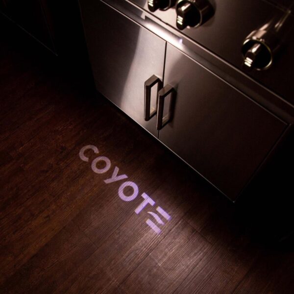 Coyote logo projected onto a wooden floor in a kitchen setting, highlighting modern kitchen design features.