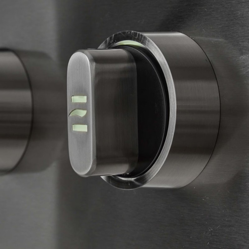 Close-up of a metallic control knob with illuminated indicators, mounted on a sleek stainless steel surface.