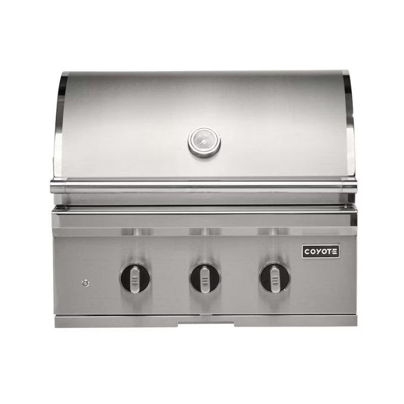 Stainless steel Coyote gas grill with three control knobs and a built-in thermometer, designed for outdoor cooking.