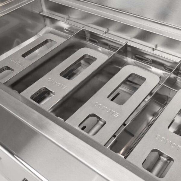 Stainless steel grill interior featuring Coyote brand cooking grates and burners, designed for outdoor cooking.