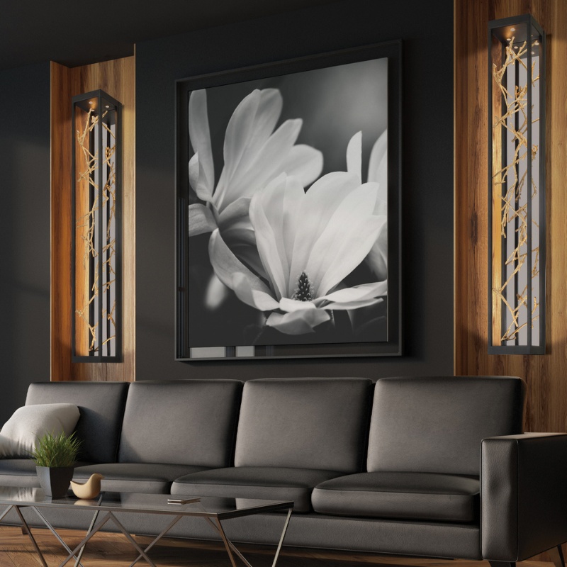 Modern living room featuring a black and white flower photograph, sleek gray sofa, and stylish wooden light fixtures.