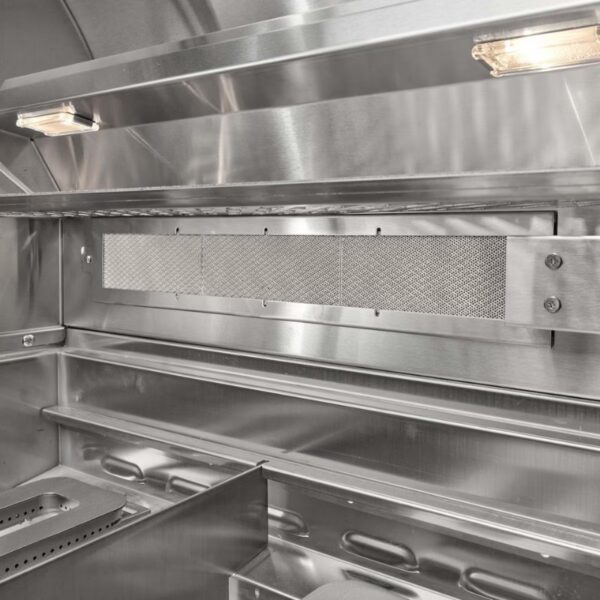 Interior view of a stainless steel commercial kitchen hood, featuring ventilation mesh and lighting, designed for efficient airflow and grease capture.