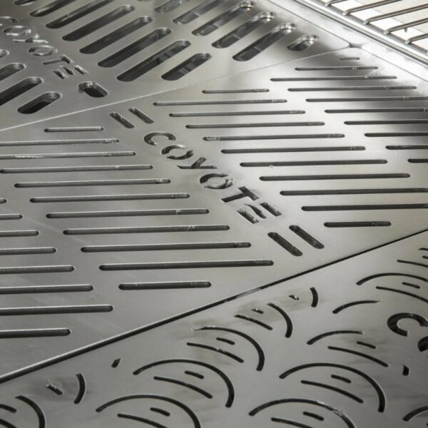 Close-up of a stainless steel grill surface featuring the Coyote brand logo and slotted design for optimal heat distribution and cooking efficiency.