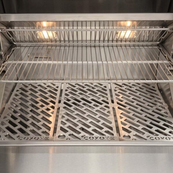 Stainless steel grill interior with adjustable wire racks and a patterned base, designed for efficient heat distribution and easy cleaning.