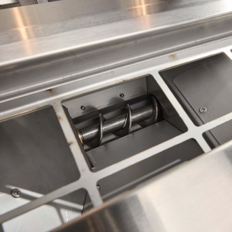 Close-up of a stainless steel commercial food processing machine with an exposed auger mechanism, showcasing its design and functionality.