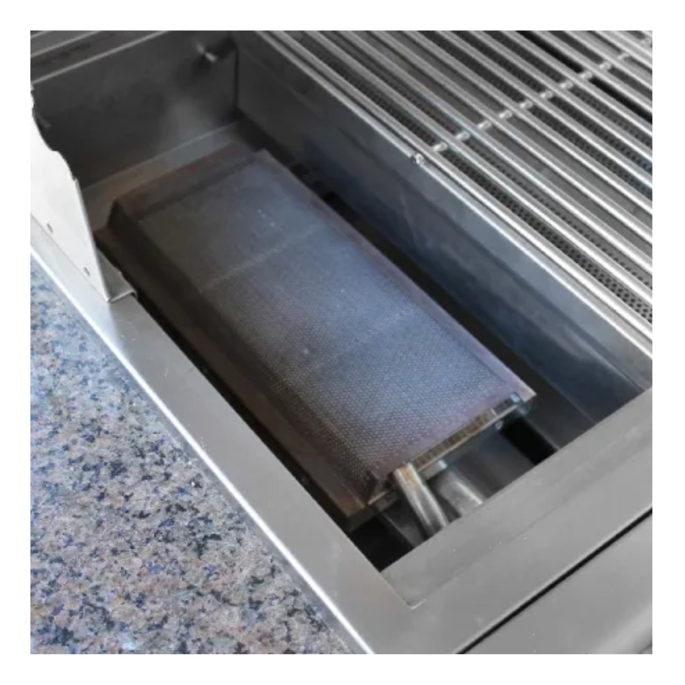 Stainless steel grill with a removable cooking plate positioned in a sleek countertop.