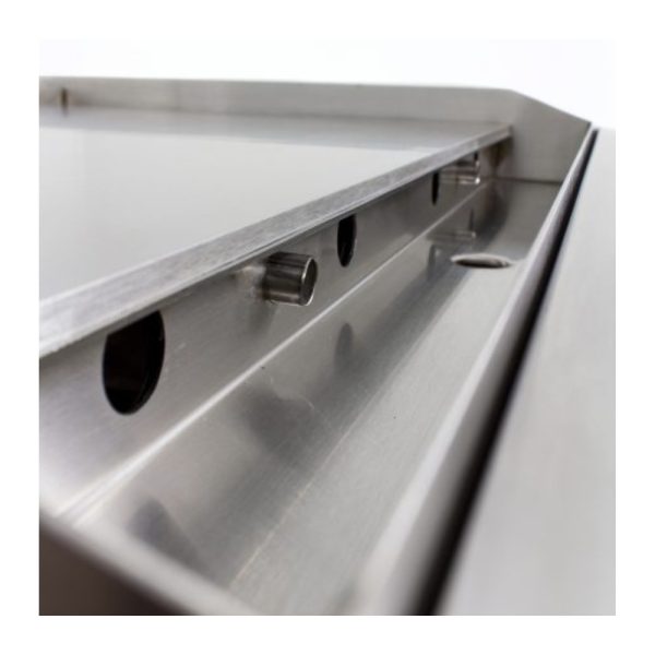 Close-up of a stainless steel countertop with drainage grooves and holes, designed for efficient water flow and easy maintenance.