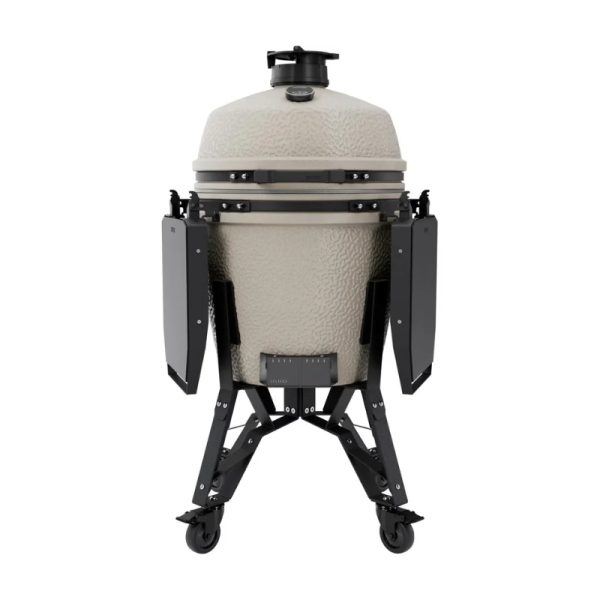 Ceramic kamado grill with a light beige finish, mounted on a sturdy black cart with wheels for mobility. Features adjustable vents and side shelves for convenience during grilling.