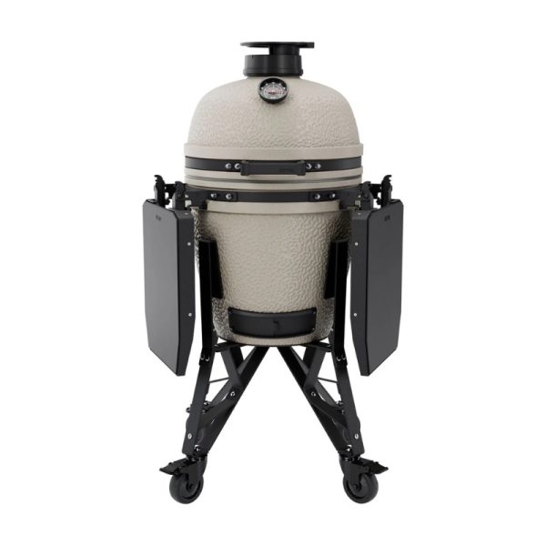 Ceramic kamado grill with a textured finish, featuring a temperature gauge, adjustable top vent, and foldable side shelves on a sturdy black cart with wheels for mobility.