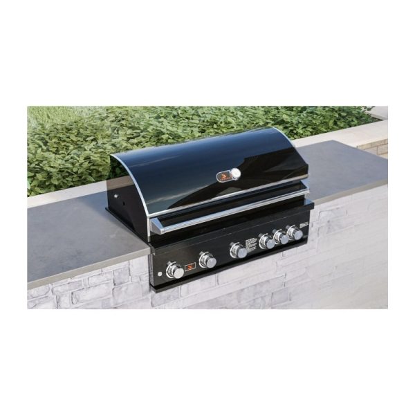 Black outdoor gas grill with stainless steel knobs, set on a stone countertop, surrounded by greenery.
