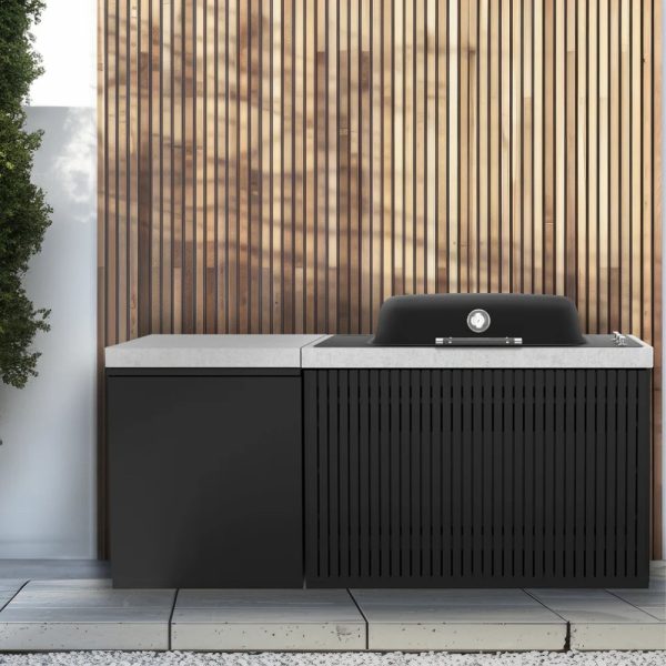 Modern outdoor kitchen featuring a sleek black grill and a stone countertop, set against a wooden slatted wall and surrounded by greenery.