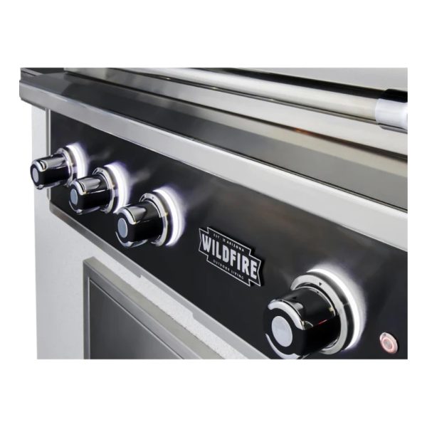 Close-up of a Wildfire outdoor grill control panel featuring four stainless steel knobs with illuminated rings, showcasing a sleek modern design.