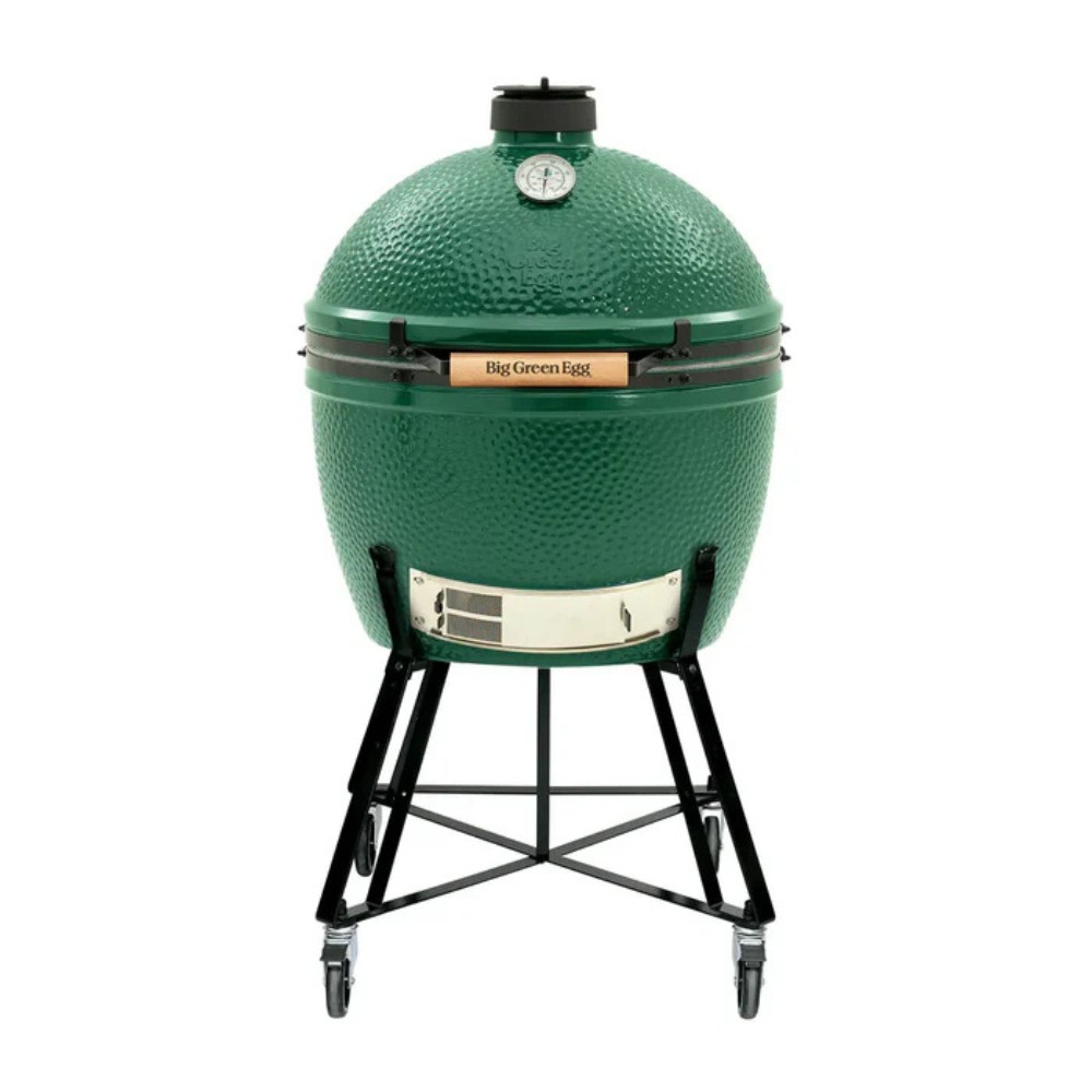 ba819728-13a2-4c78-9214-c66182bf6c5a.jpg Big Green Egg ceramic grill with a distinctive green dome, mounted on a black wheeled stand, featuring a temperature gauge on top and a wooden handle. Ideal for grilling, smoking, and baking.