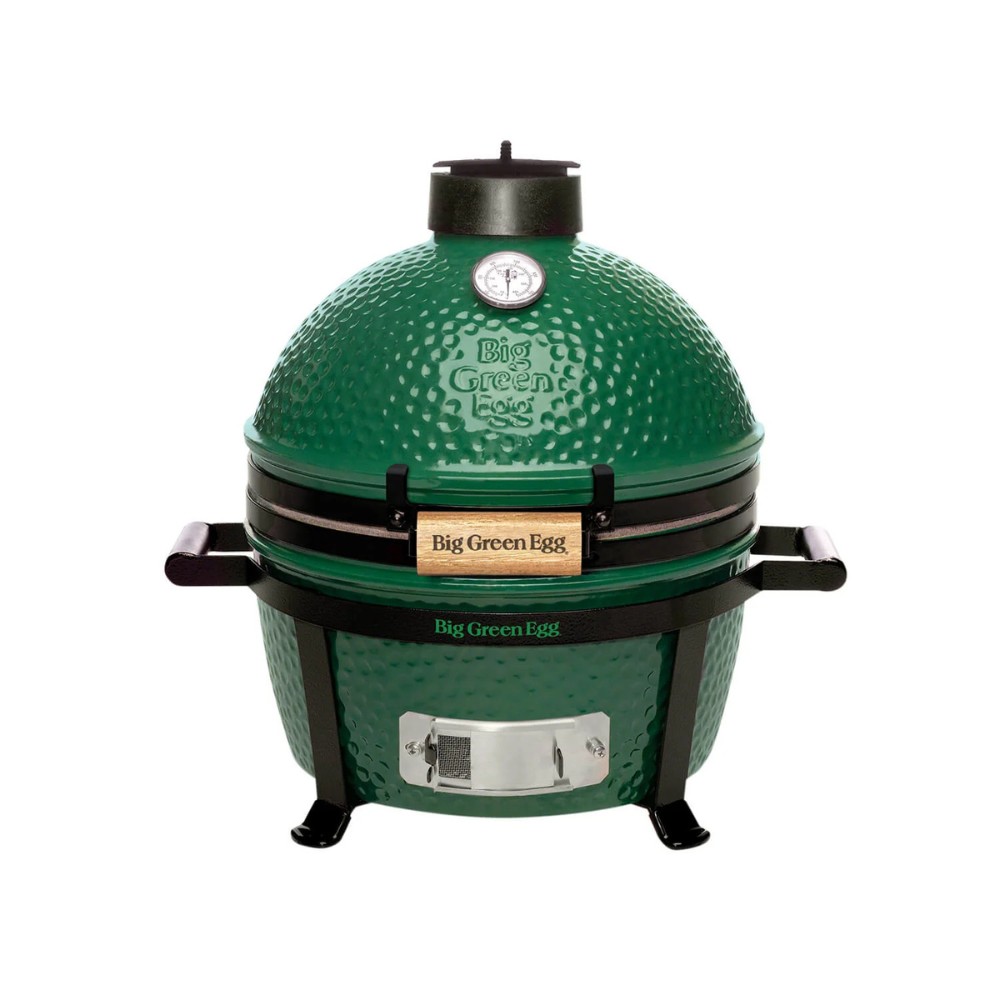 dc6042a7-07c5-4ced-8034-0dc3e50732d7.jpg Big Green Egg ceramic grill with a distinctive green dome, featuring a temperature gauge and wooden handle, designed for versatile cooking.